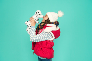 kid toy shop. small girl hold dog toy. kid love her fluffy pet puppy. winter activity and fun. childhood happiness. fashion kid turquoise background. child happy to play with toy