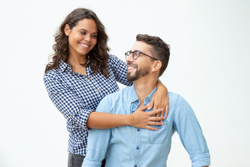 Naklejka premium Happy young couple smiling each other. Cheerful boyfriend and girlfriend embracing and looking at each other on white background. Relationship concept