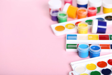 Colorful gouache paints on pink background