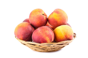 Fresh peaches in basket isolated on white background