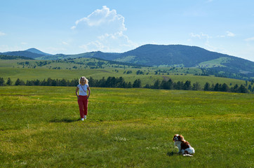Fototapeta na wymiar Woman and dog in a wonderful mountain landscape in spring