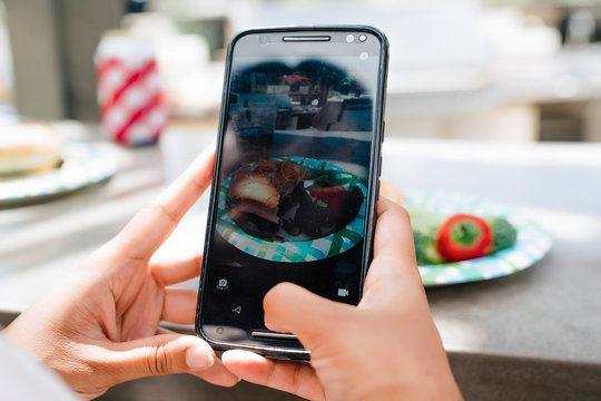 Woman taking photo of food at party with cell phone