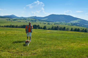 Man and his dog in a wonderful mountain landscape in spring