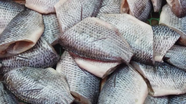 Many raw gutted fishes close up on fish market in Asia without cold chain.