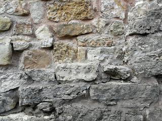 Old wall made of rocks. Medieval rocky surface. Texture of an old rocks and cement. 