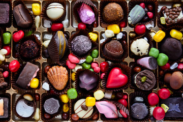 An assortment of gourmet multi-colored sweets with heart. top view. Mix of expensive chocolates. Handmade.
