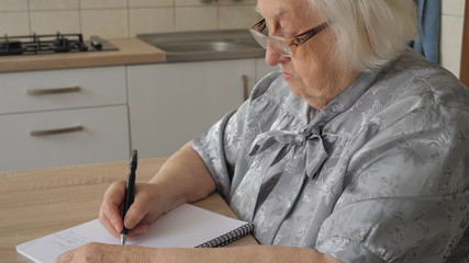 Old woman is writing letter or the last will