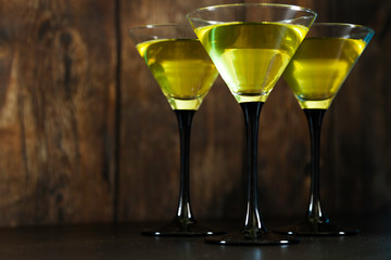 yellow cocktails glasses on old wood background