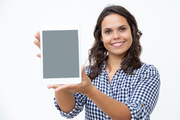 Obraz premium Content woman showing digital tablet. Beautiful happy young woman showing tablet computer with blank screen and smiling at camera. Advertisement concept