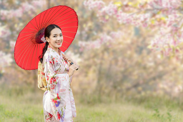 Japanese girl wearing a kimono holding a red umbrella. Beautiful Female wearing traditional...