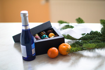 new year presents on the table. blue bottle of champagne, candys and mandarin