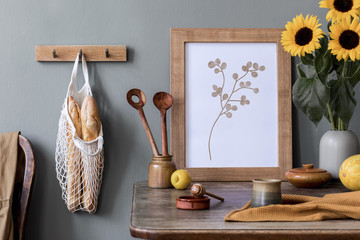 Stylish interior design of kitchen space with wooden table, mock up frame, bag with bagles, honey,...