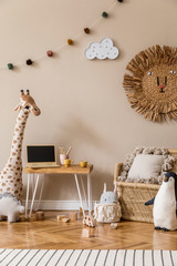 Stylish scandinavian interior of child room with natural toys, hanging decoration, design furniture, plush animals, teddy bears and accessories. Beige walls. Interior design of kid room. Template.