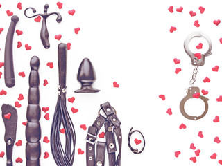 Various sex (dildo, butt plug, leather lash, harness, handcuffs) toys are on a white background....