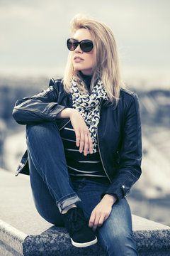 Happy young fashion woman in leather jacket and sunglasses