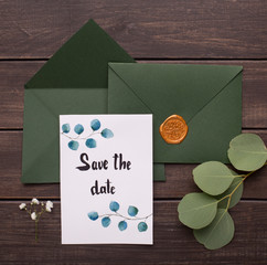 Wedding Green envelopes with postcard inside on wood