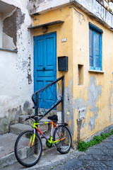 Fototapeta na wymiar Procida (Italy) - Colored walls and bike in Procida, a little island in Campania, southern Italy