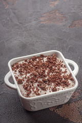 Tasty pudding with chocolate crumble cookie in ceramic form. Dark.