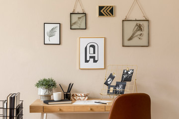 Stylish scandinavian interior of home office space with a lot of mock up photo frames, wooden desk, brown chair, plants, office and personal accessories. Modern neutral home staging. Template.
