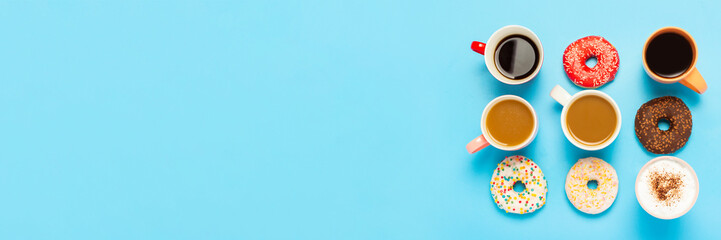 Tasty donuts and cups with hot drinks, coffee, cappuccino, tea on a blue background. Concept of...