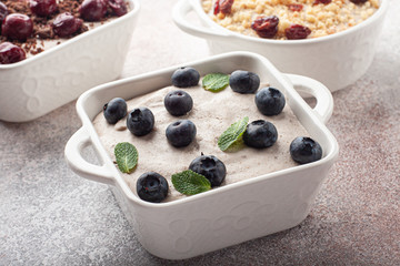 Tasty homemade pudding with chocolate crumble cookie in ceramic plate on wooden background. Few pudding