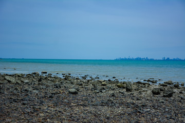 Stone courtyard on the public beach,Beautiful seascape with natural stone yard on beach against cloudy sky,Rocky shore at the seacoast with seascape and blue sky,