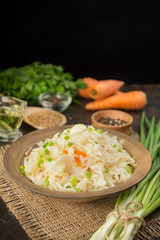 Sauerkraut with carrots in a bowl. Homemade food. Sour food. Pickled vegetables. Vegetarian vegan food. Side view .
