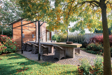 Large decorated concrete table covered by a glass gazebo in an autumn garden.