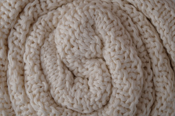 Texture of a white woolen plaid rolled up, close-up, abstract background.
