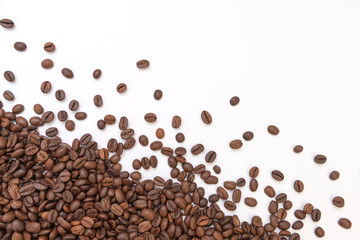 fresh roasted coffee beans sprinkled on a white background
