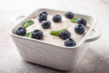 Tasty homemade pudding with blueberry in square ceramic plate.