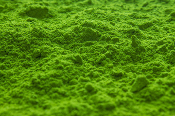 Blurred background: traditional Japanese powdered green matcha tea is scattered on the surface in...