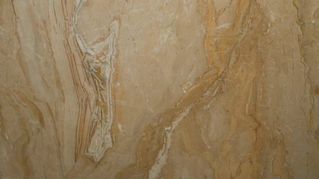 Solid piece of marble in beige tones in a modern interior for interior decoration of the bathroom and kitchen, sliding the camera from top to bottom.