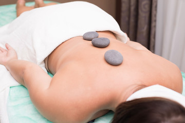 Portrait of a young woman blissfully enjoying spa therapy. close-up. Massage stones