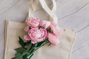 Bouquet of pink peonies on eco bag