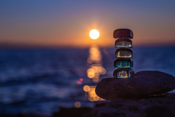 Pyramid of colored glass against the background of the sunset sea and sky in the Blue hour