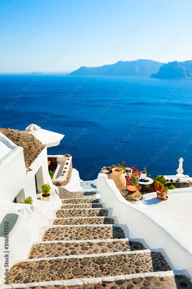 Wall mural white architecture and blue sea on santorini island, greece. stairs to the sea. summer holidays, tra