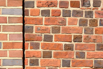 Fototapeta premium Red and gray bricks old vintage wall. Abstract architectural background for design.