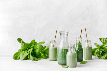 Detox green smoothies in glass bottles with eco friendly straws, front view