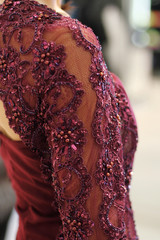Obraz premium Haute couture fashion detail. Beautiful luxury red dress, close up. Embroidered sleeves on evening dress. 