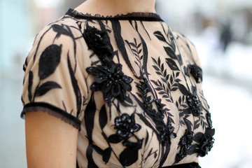 Haute couture fashion detail. Beautiful luxury black and beige dress, close up. Embroidered evening...