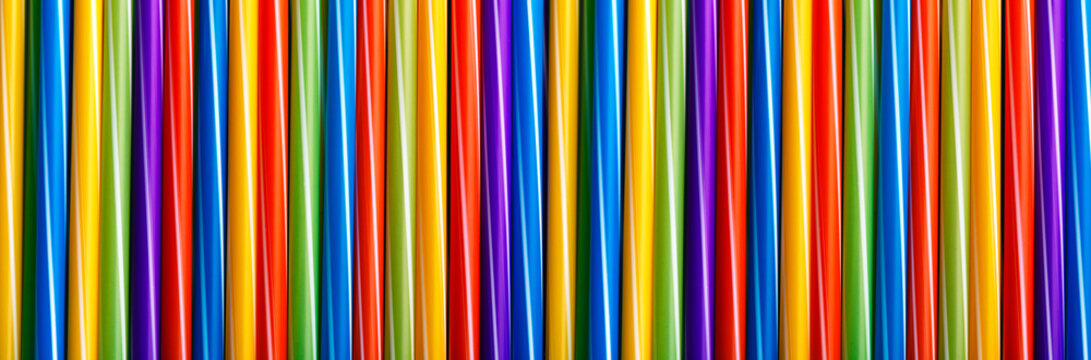 Many different colored plastic drinking straws vertically arranged, panoramic image