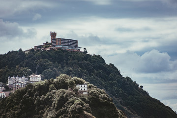 Fototapeta na wymiar bahia de san sebastian donostia dia nublado hotel torre sobre la montaña