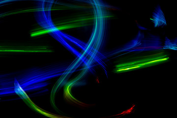 Abstract color pattern of luminous stripes on a black background, bright and smooth color streaks
