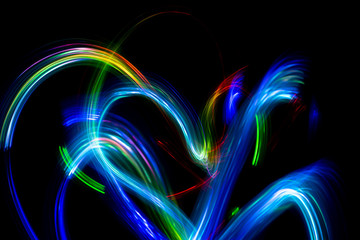 Abstract color pattern of luminous stripes on a black background, bright and smooth color streaks