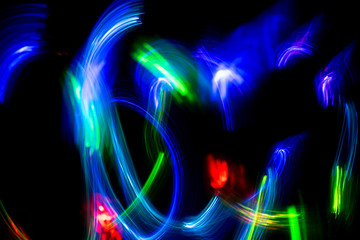 Abstract color pattern of luminous stripes on a black background, bright and smooth color streaks