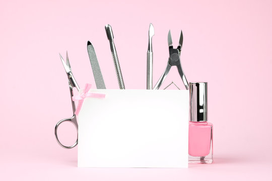 Manicure tools on a pink background, white card with place for text, template for advertising of beauty salons. Beauty and body care concept.