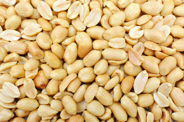 Fried salted peanuts close-up background. Groundnut texture.
