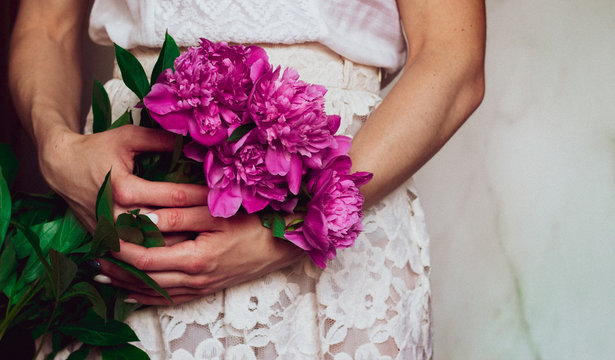 woman holding beautiful bouque of peonies, close up