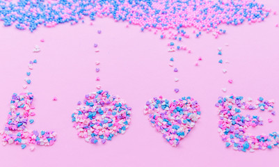 Cloud from decorative balls  on pink background with pink , purple and blue  hearts falling down and lettering Love